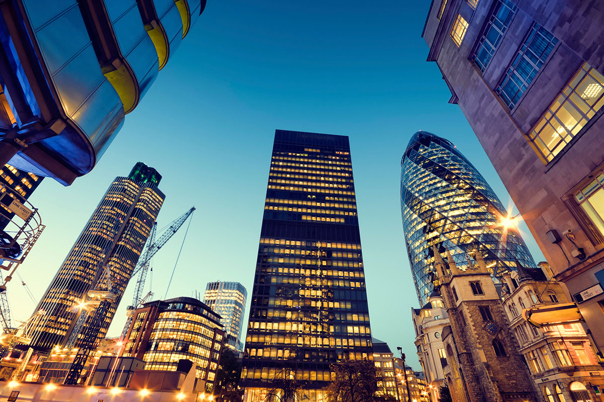 sunset view of buildings and skyscrapers with lights through windows